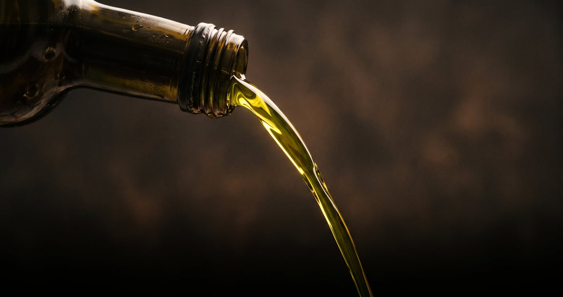 Extra virgin olive oil pouring from a dark glass bottle — natural GLP-1 alternative to Ozempic